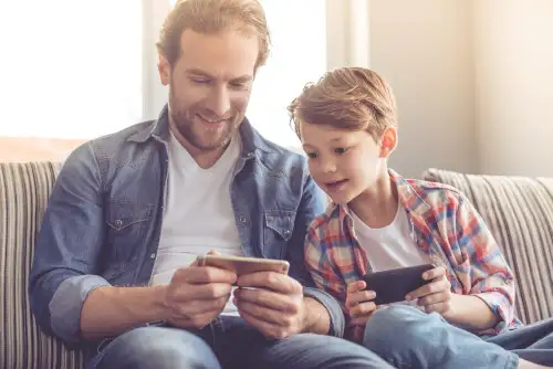 A father and son use their phones together